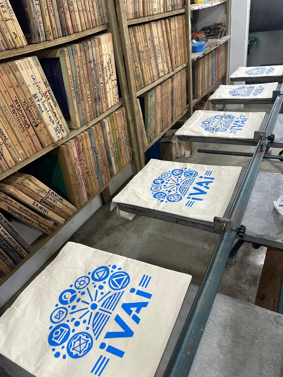 Ecobags com estampa azul na bancada de produção